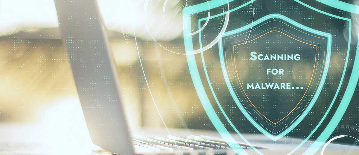 Imagen de un escudo digital con las palabras "Escaneando en busca de malware..." sobre una computadora portátil.